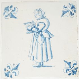 Antique Delft wall tile depicting a lace maker holding a frame and spool, painted in blue with fleur-de-lis corner motifs, 17th century