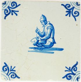 Antique Delft wall tile with a seated tailor at work, 17th century