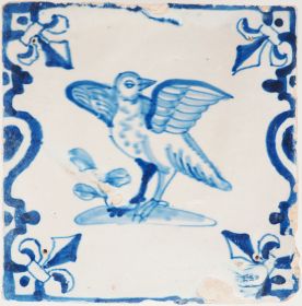 Antique Delft wall tile depicting a bird with outstretched wings beside foliage, 17th century