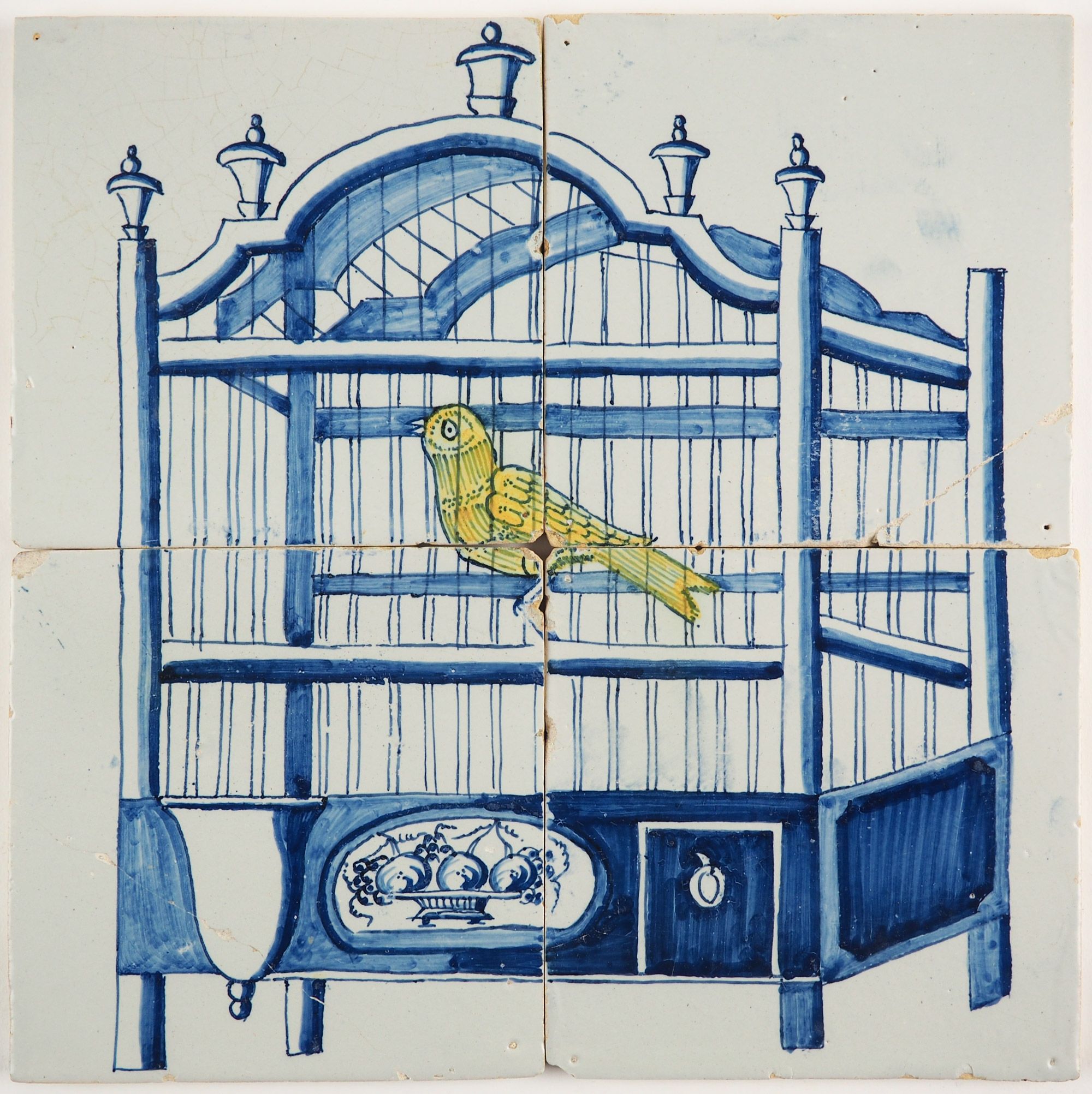 Antique Delft tile mural in blue with a yellow canary in a bird