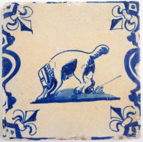 Antique Delft tile with a dog with a bone in his mouth, 17th century