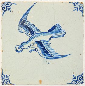 Antique Delft tile in blue with a bird in flight holding a piece of fruit in its beak, 17th century
