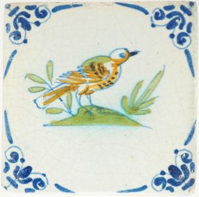Antique Delft tile with a bird on a patch of grass, 17th century