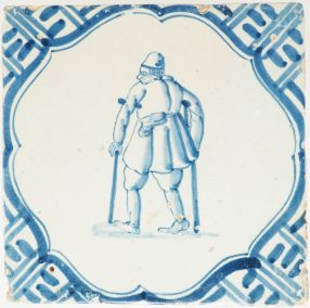Antique Delft tile with a man on crutches and Wanli corner motifs, 17th century