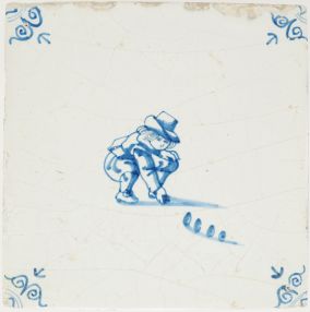 Antique Delft tile with child playing marbles in blue, 17th century