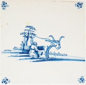 Antique Delft tile showing a woman milking a cow, 18th century