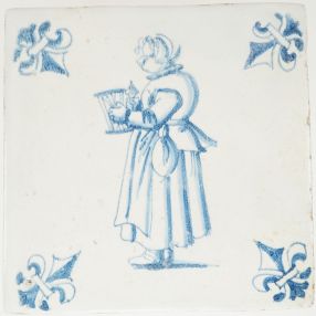 Antique Delft wall tile depicting a lace maker holding a frame and spool, painted in blue with fleur-de-lis corner motifs, 17th century