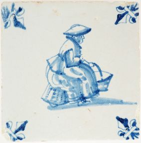 Antique Delft wall tile depicting a market woman carrying baskets of goods, 17th century