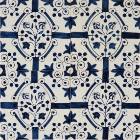 Hand-painted Delft tiles depicting flower inside oval border, decorated with fleur-de-lis corner motifs and royal charter motifs around the border. 
