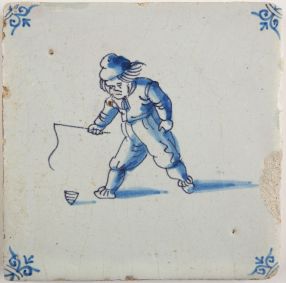 Antique Delft tile with a child playing with a spinning top, 17th century