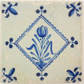 Antique Delft tile with a flower in diamond square, 17th century