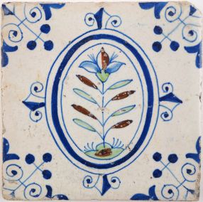 Antique Delft tile with a polychrome flower in an oval border, 17th century 