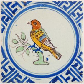 Antique Delft tile with a polychrome bird in Wanli inspired corner motifs, 17th century