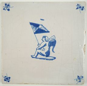 Antique Delft tile with Cupid sitting while holding a flag, late 17th century